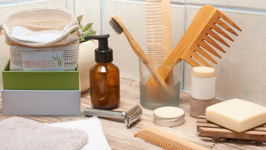 Des accessoires de salle de bain zéro déchet alignés sur une surface naturelle : pads lavables en bambou, savon solide, brosse à dents en bambou et shampoing solide — lumière douce, ambiance naturelle et épurée.